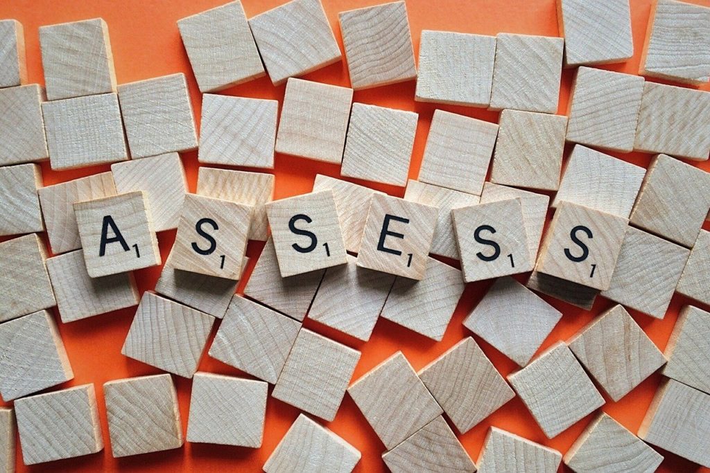 Scrabble letters spelling ASSESS