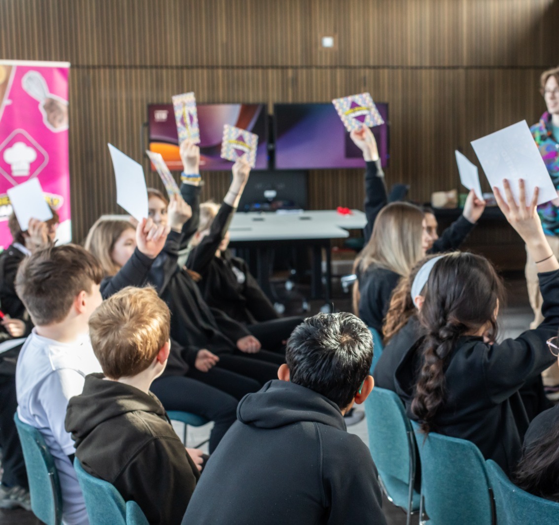 Young people putting up their hands in a workshop